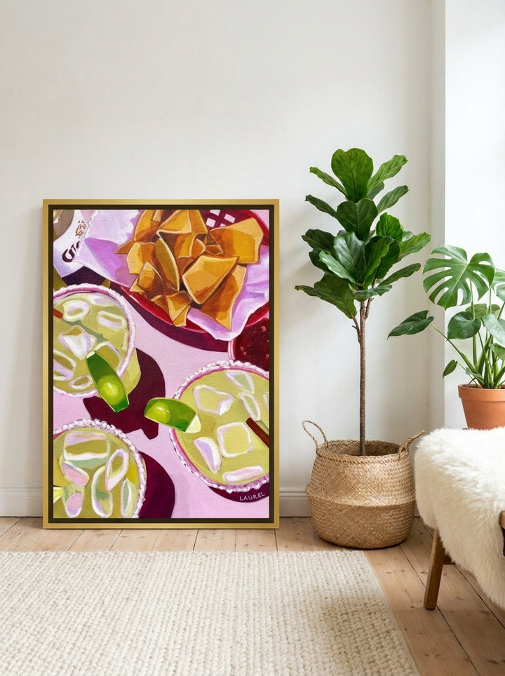 Canvas wall art with a gold leaf surround leaning against the wall in a bright Scandinavian living room