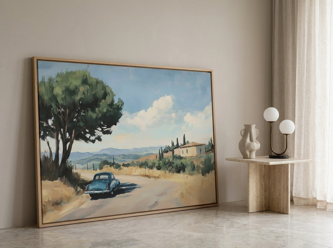 Oversized statement canvas wall art with a natural timber surround leaning against the wall in a luxe living room