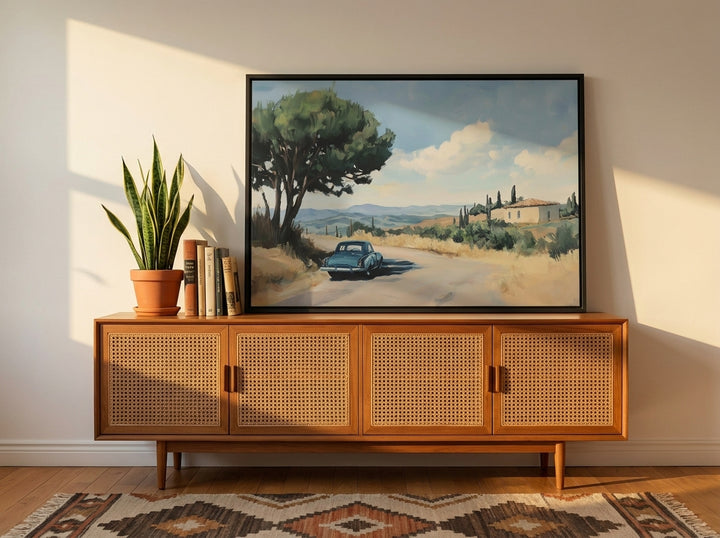 Canvas wall art with a black surround standing on a sideboard in a mid-century dining room