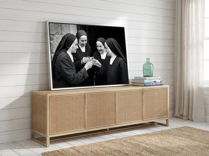 Canvas wall art with a silver leaf surround standing on a sideboard in a coastal home office