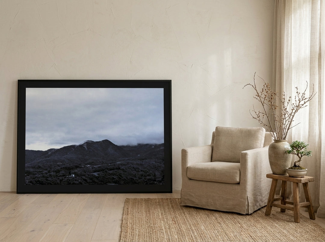 Oversized statement modern wall art print leaning against the wall in a warm Japandi bedroom