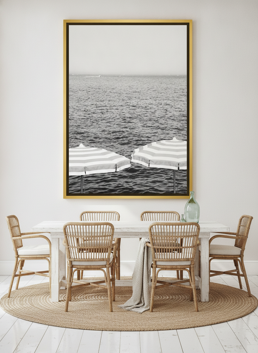 Oversized statement canvas wall art with a gold leaf surround styled on the wall in a coastal dining room