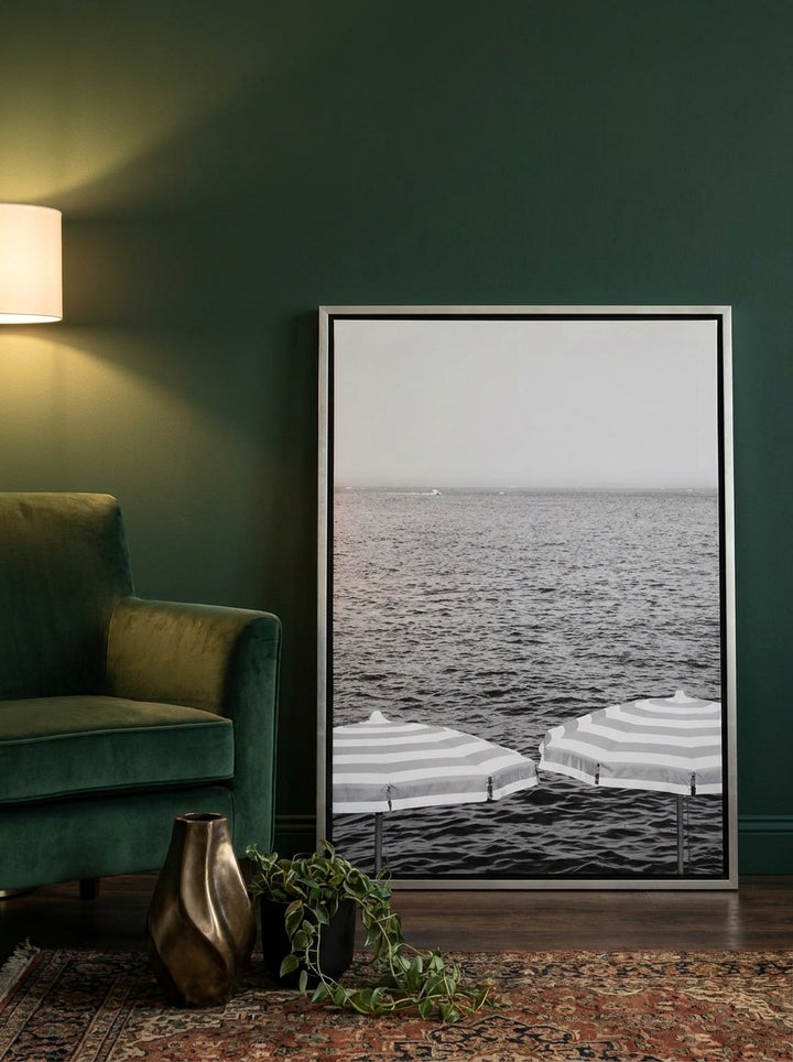 Canvas wall art with a silver leaf surround leaning against the wall in a moody living room