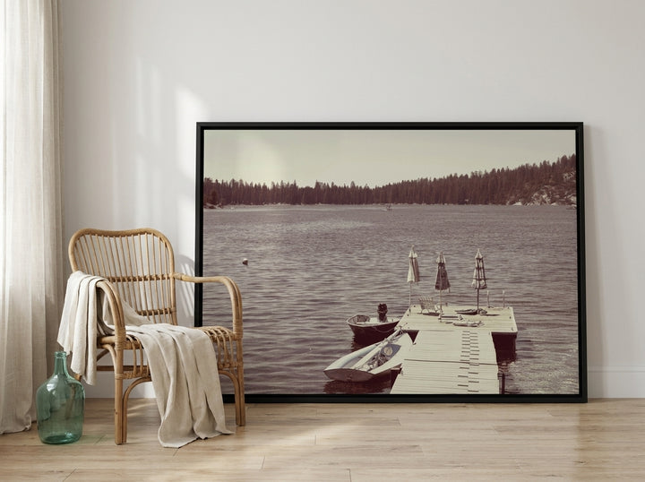 Oversized statement canvas wall art with a black surround leaning against the wall in a coastal bedroom