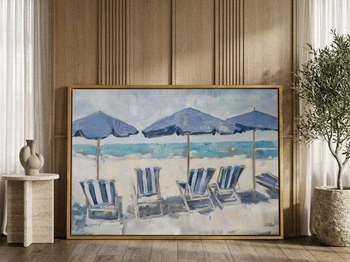 Canvas wall art with a gold leaf surround leaning against the wall in a luxe bedroom