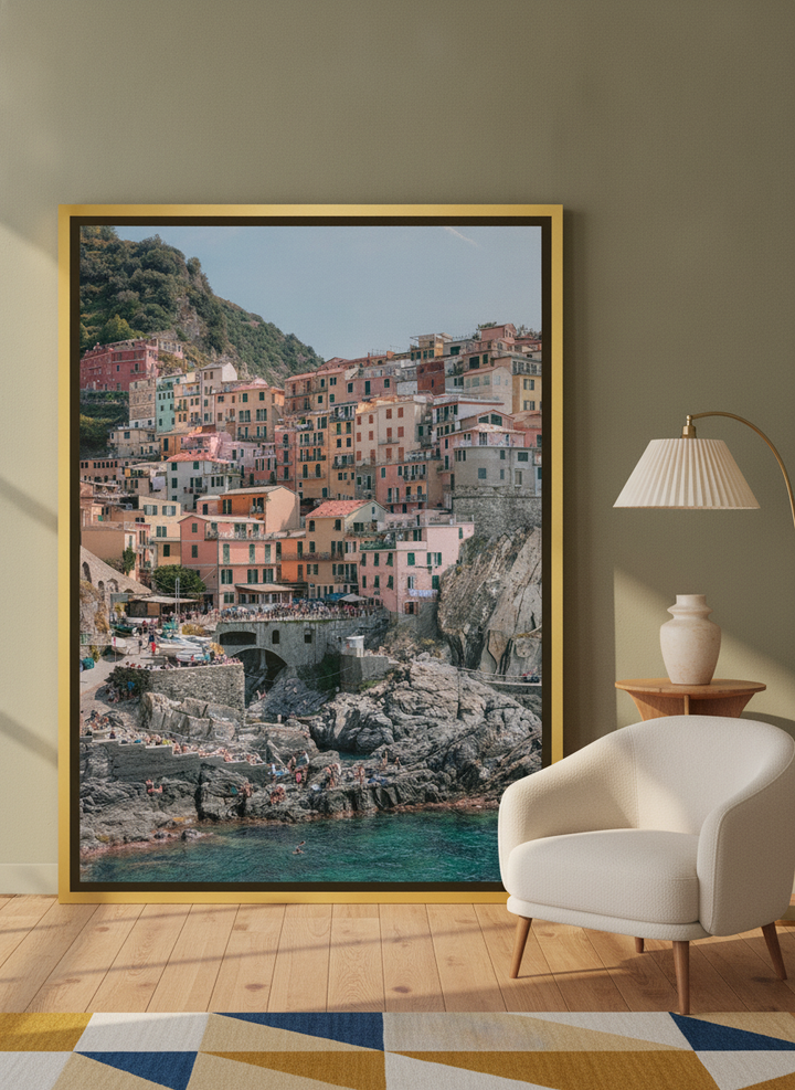 Oversized statement canvas wall art with a gold leaf surround leaning against the wall in a mid-century living room