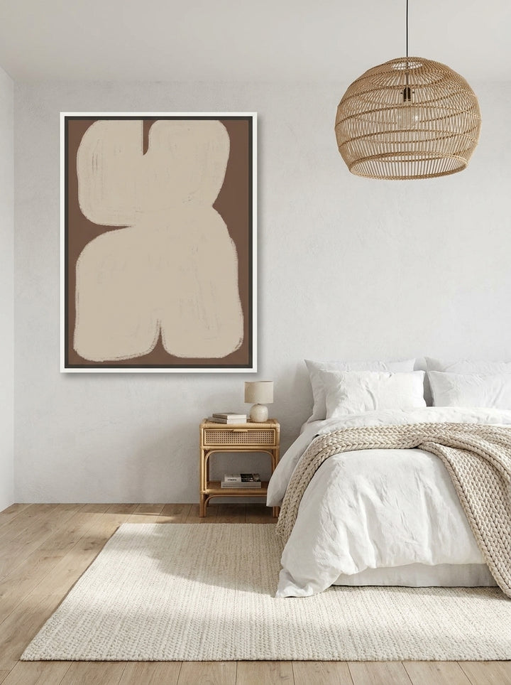 Canvas wall art with a white surround styled on the wall in a bright Scandinavian bedroom