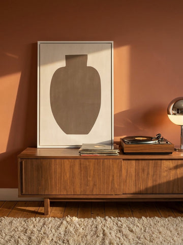 Canvas wall art with a white surround standing on a sideboard in a retro 70s bedroom
