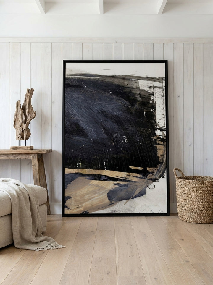 Oversized statement canvas wall art with a black surround leaning against the wall in a coastal living room