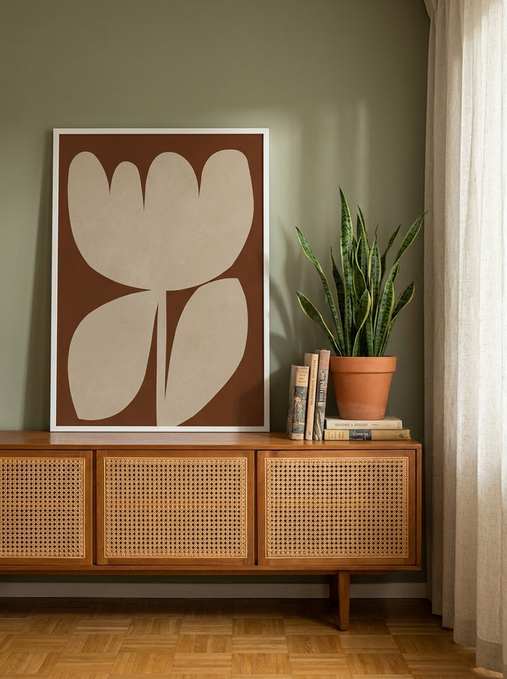 Modern wall art print standing on a sideboard in a mid-century home office