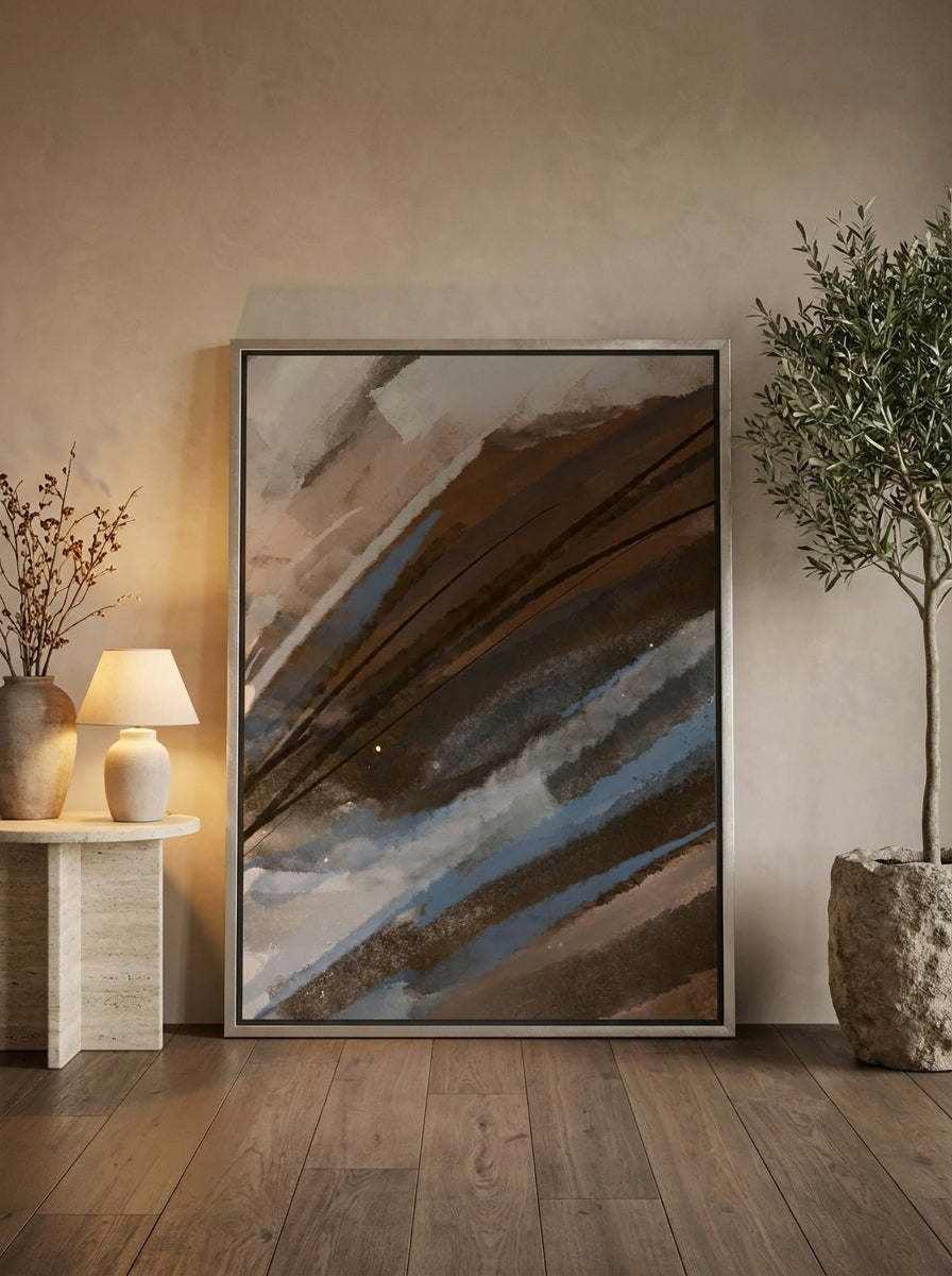 Oversized statement canvas wall art with a silver leaf surround leaning against the wall in a luxe bedroom
