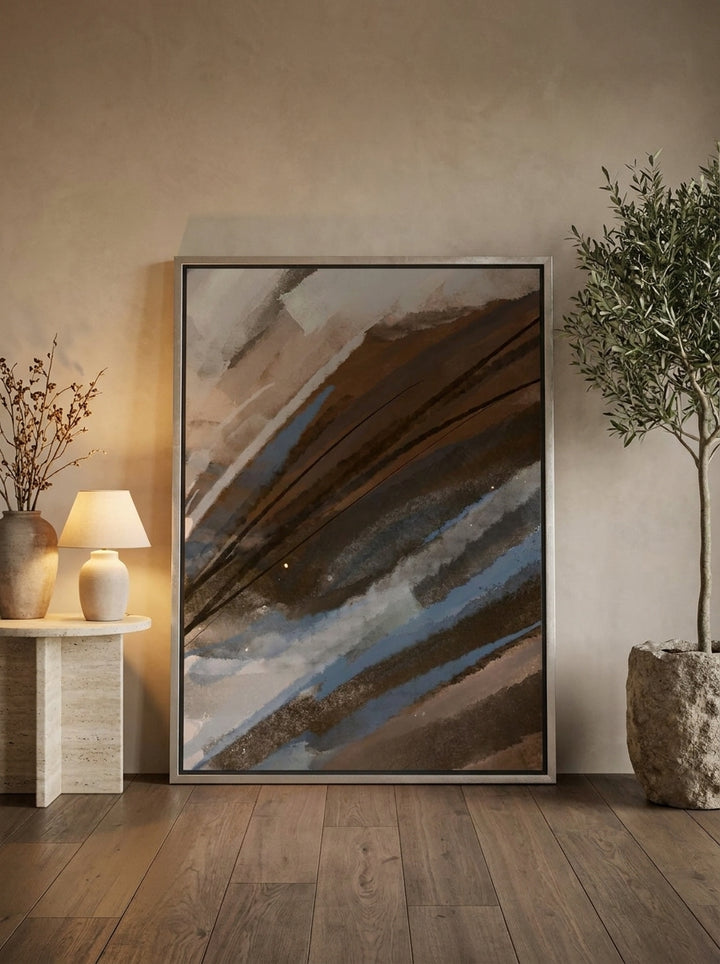 Oversized statement canvas wall art with a silver leaf surround leaning against the wall in a luxe bedroom