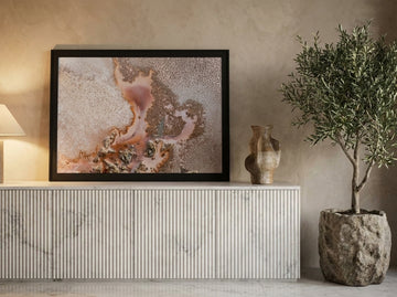 Modern wall art print standing on a sideboard in a luxe bedroom