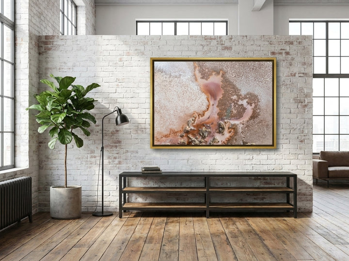 Oversized statement canvas wall art with a gold leaf surround styled on the wall in an industrial loft living room