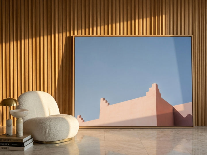 Oversized statement canvas wall art with a natural timber surround leaning against the wall in a luxe dining room
