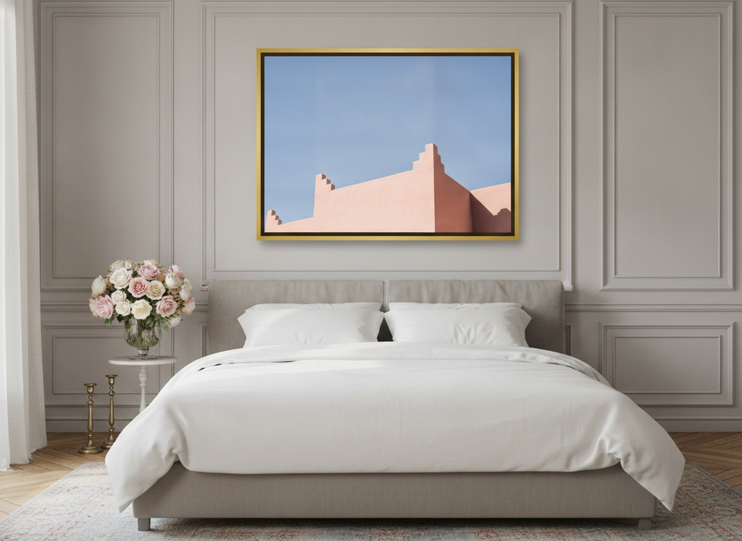 Canvas wall art with a gold leaf surround styled on the wall in a Parisian bedroom