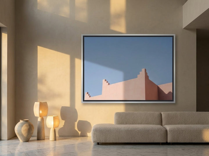 Oversized statement canvas wall art with a silver leaf surround styled on the wall in a luxe living room
