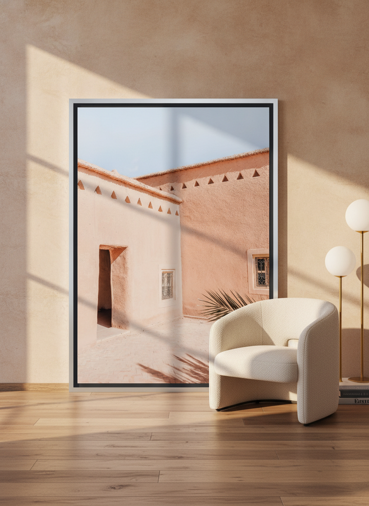 Oversized statement canvas wall art with a silver leaf surround leaning against the wall in a luxe dining room