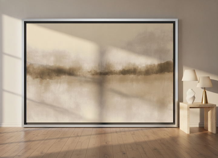 Oversized statement canvas wall art with a silver leaf surround leaning against the wall in a luxe living room