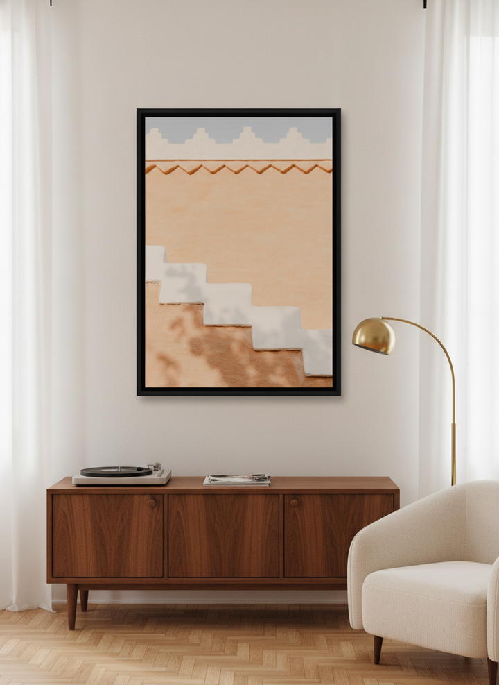 Canvas wall art with a black surround styled on the wall in a mid-century living room