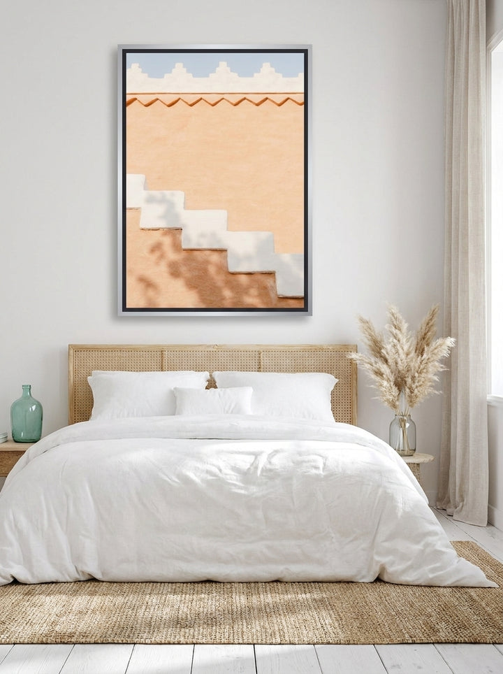 Oversized statement canvas wall art with a silver leaf surround styled on the wall in a coastal bedroom