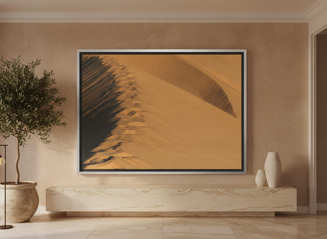 Oversized statement canvas wall art with a silver leaf surround styled on the wall in a luxe living room