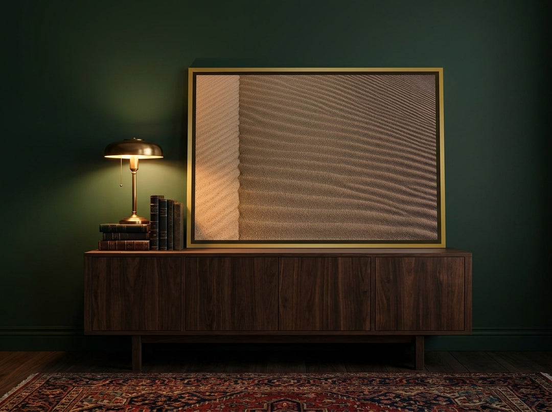 Canvas wall art with a gold leaf surround standing on a sideboard in a moody home office