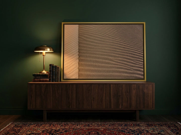 Canvas wall art with a gold leaf surround standing on a sideboard in a moody home office