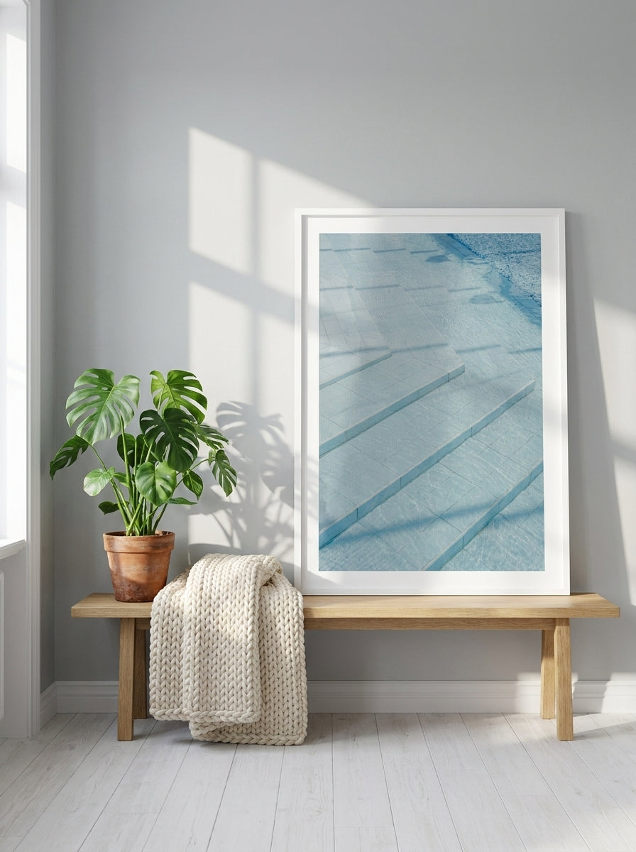 Modern wall art print standing on a bench in a bright Scandinavian bedroom