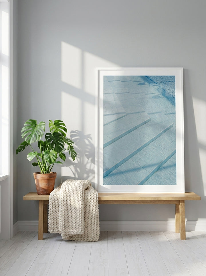 Modern wall art print standing on a bench in a bright Scandinavian bedroom