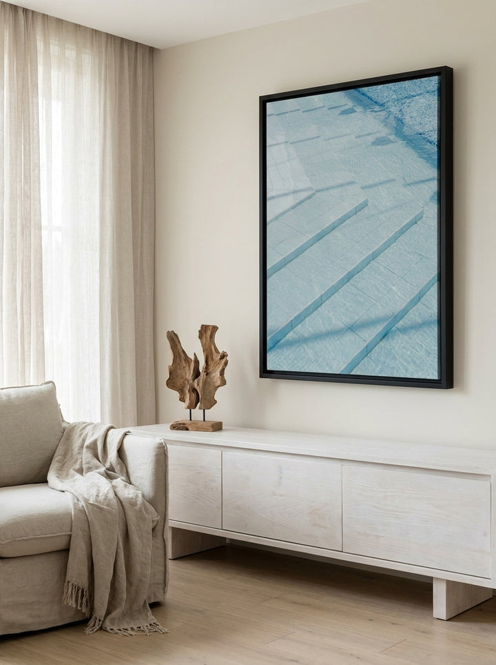 Oversized statement canvas wall art with a black surround styled on the wall in a coastal living room