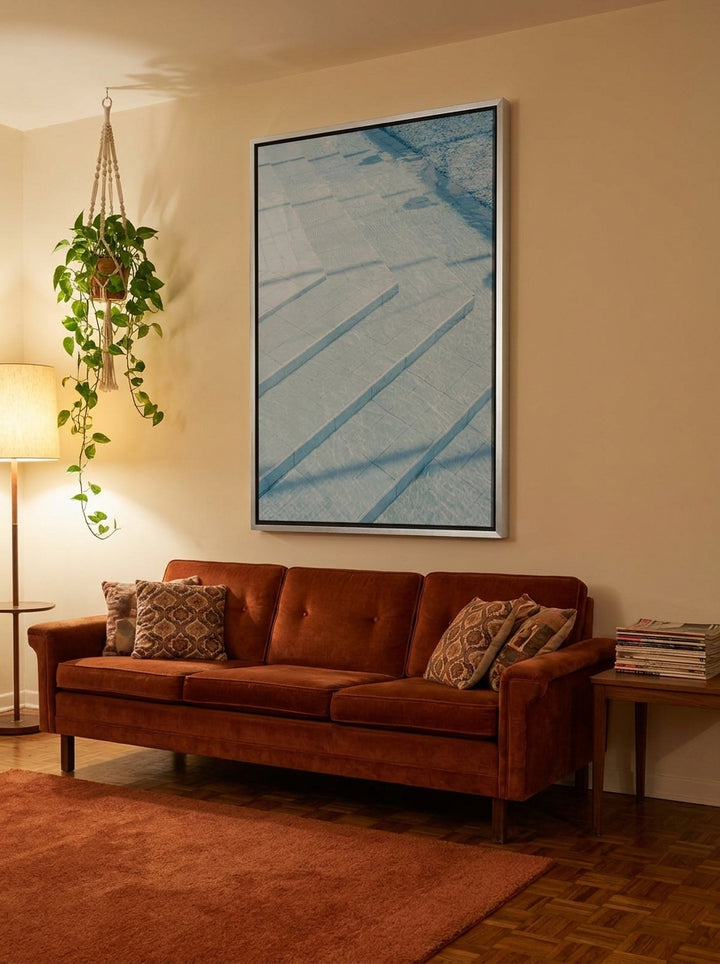 Oversized statement canvas wall art with a silver leaf surround styled on the wall in a retro 70s living room
