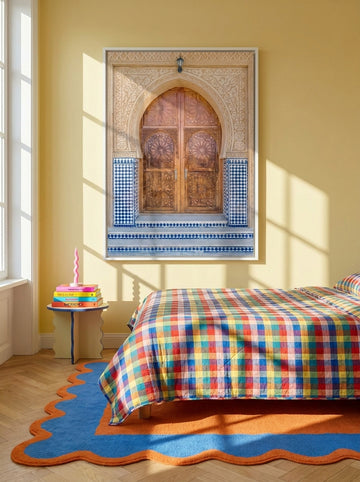 Canvas wall art with a white surround styled on the wall in a colourful eclectic bedroom