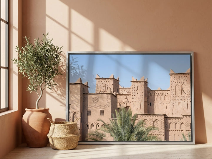 Canvas wall art with a silver leaf surround leaning against the wall in a Mediterranean bedroom