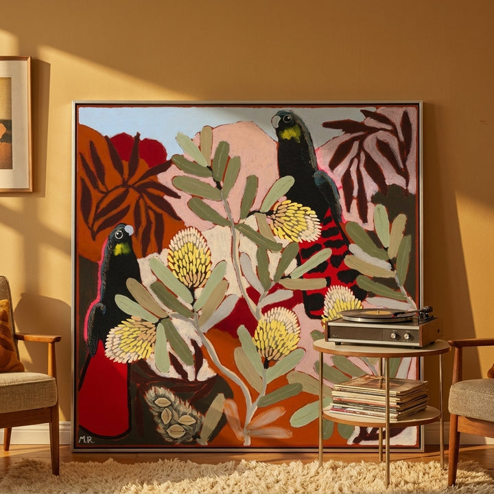 Oversized statement canvas wall art with a silver leaf surround leaning against the wall in a retro 70s living room