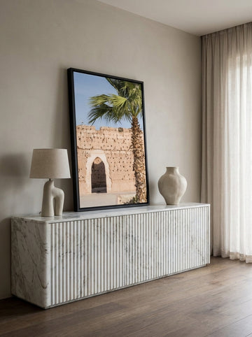 Canvas wall art with a black surround standing on a sideboard in a luxe living room