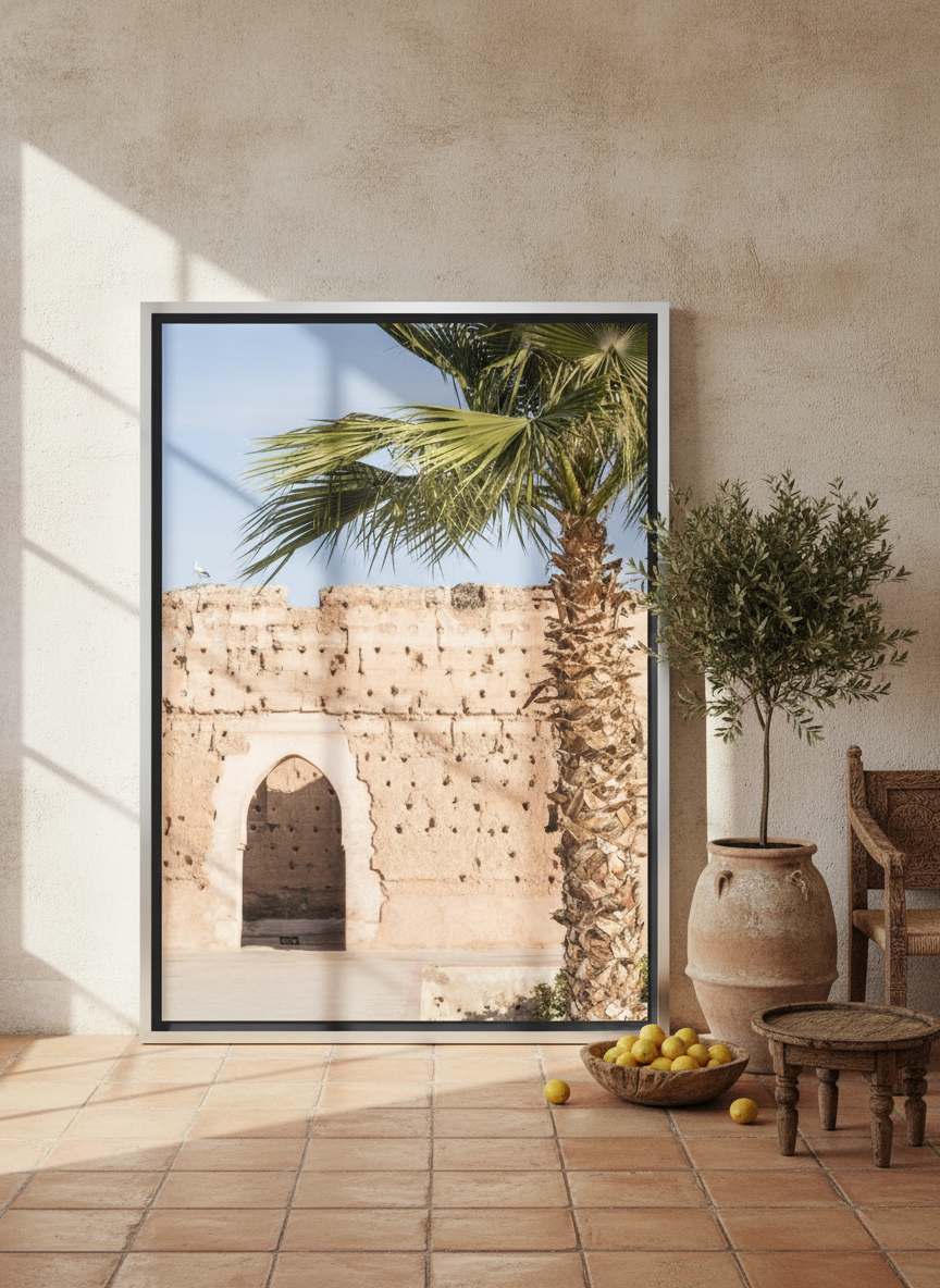 Oversized statement canvas wall art with a silver leaf surround leaning against the wall in a Mediterranean dining room