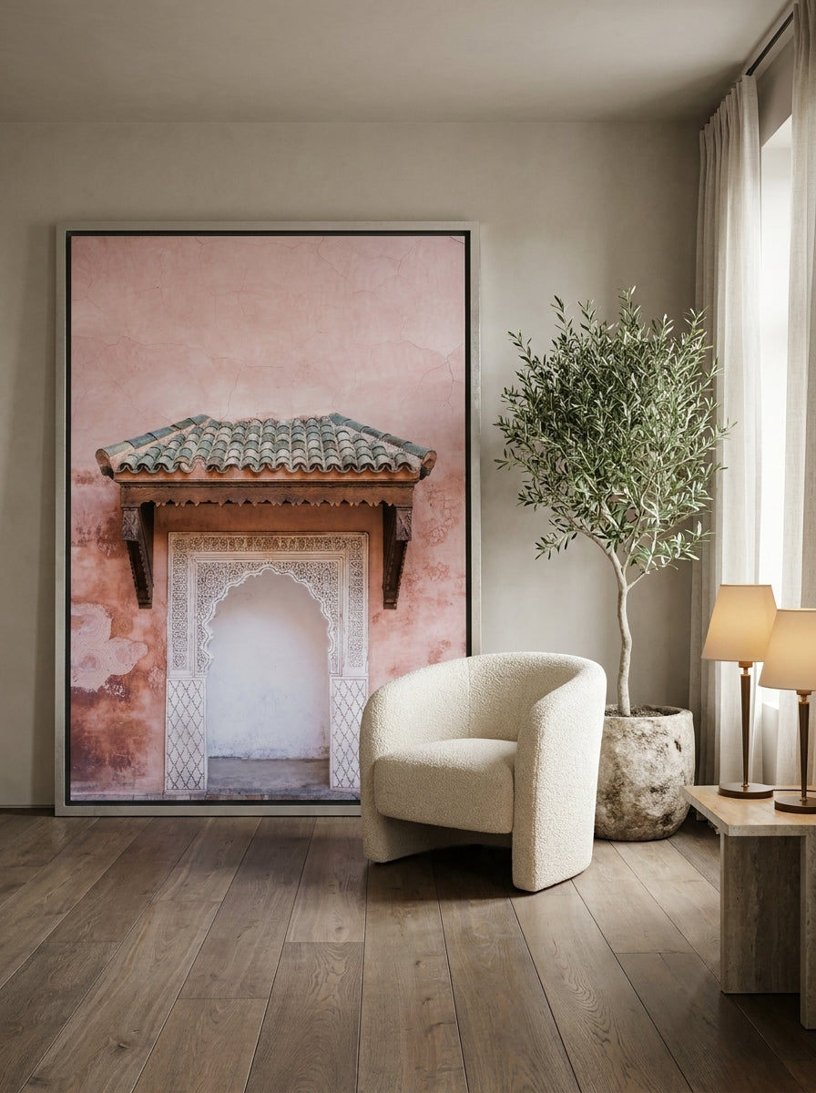 Oversized statement canvas wall art with a silver leaf surround leaning against the wall in a luxe bedroom