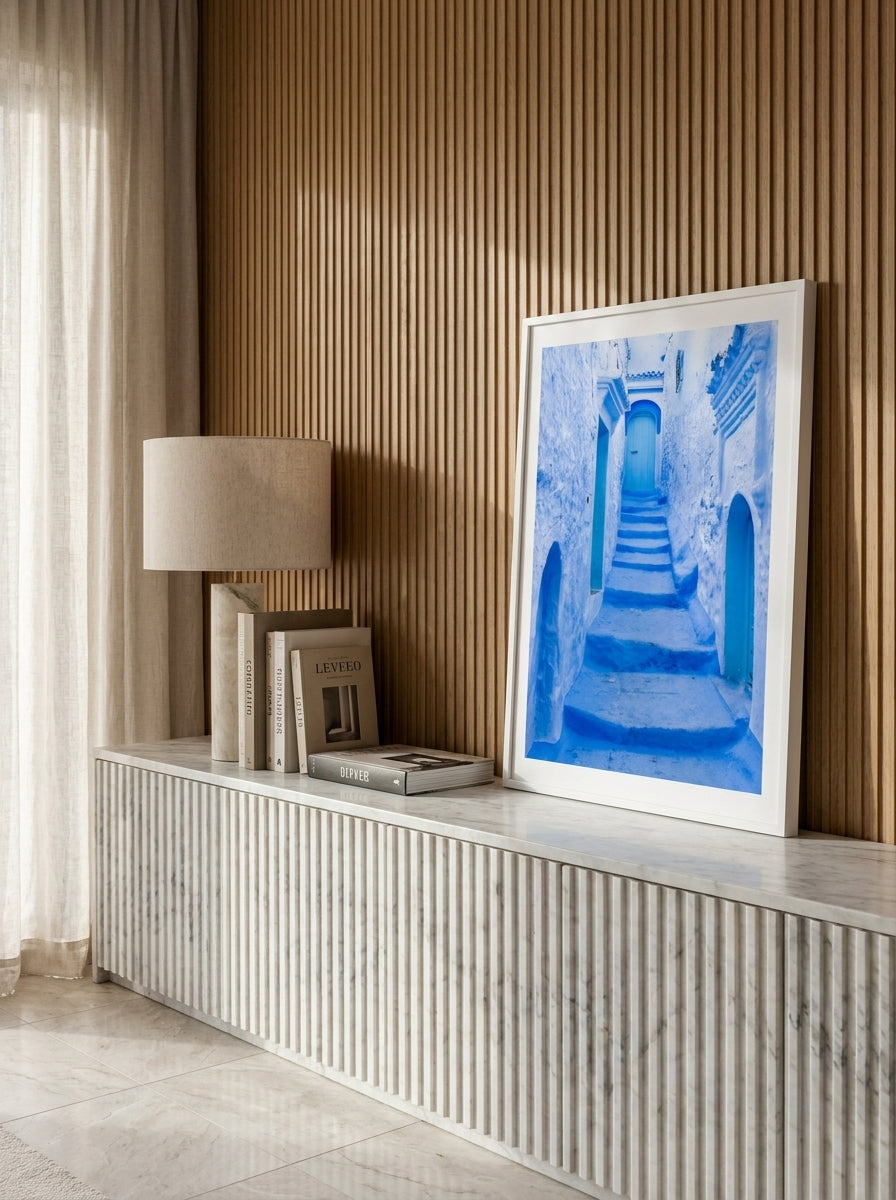 Modern wall art print standing on a sideboard in a luxe bedroom