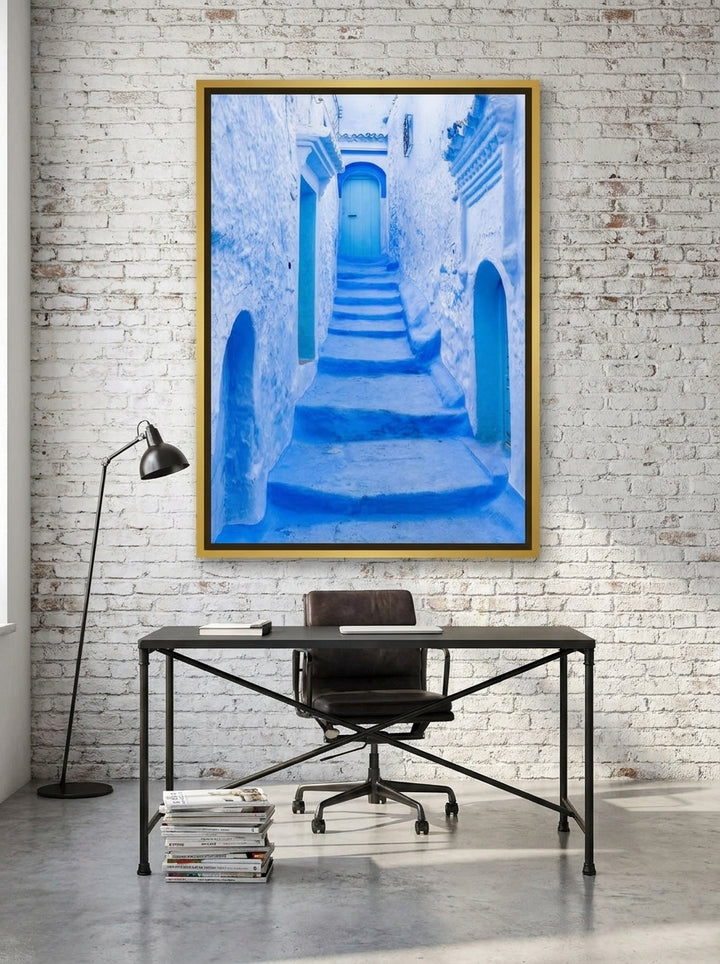 Oversized statement canvas wall art with a gold leaf surround styled on the wall in an industrial loft home office