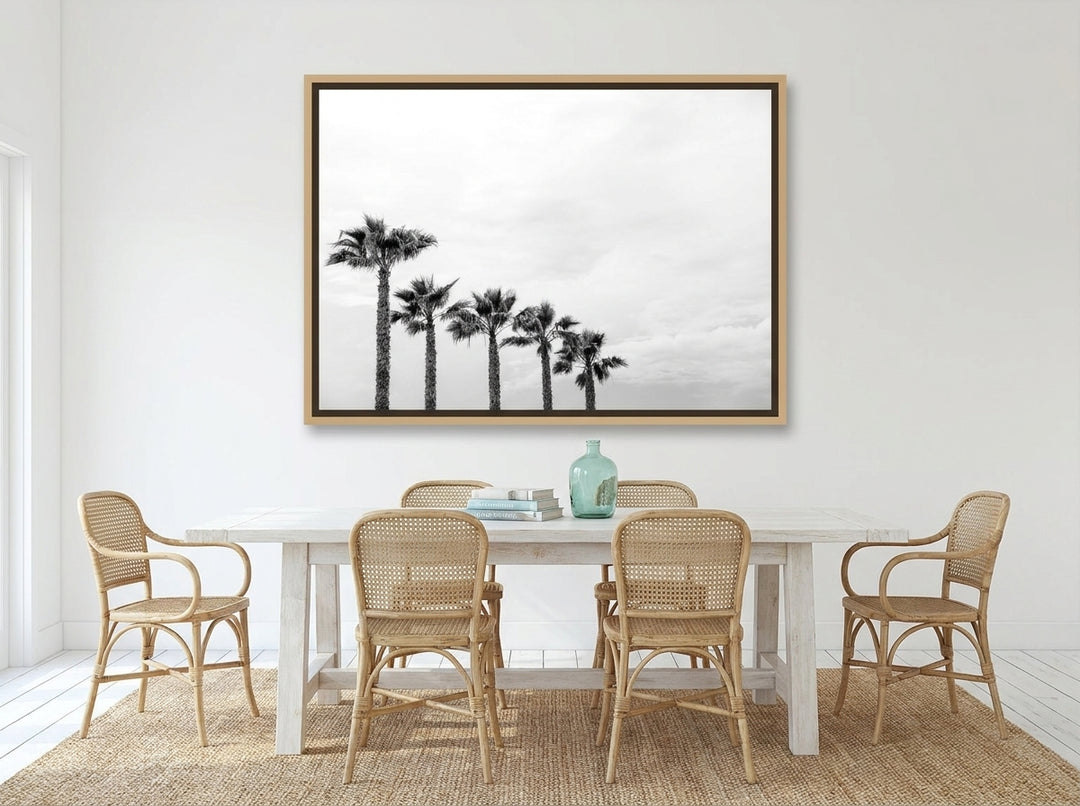 Oversized statement canvas wall art with a natural timber surround styled on the wall in a coastal dining room