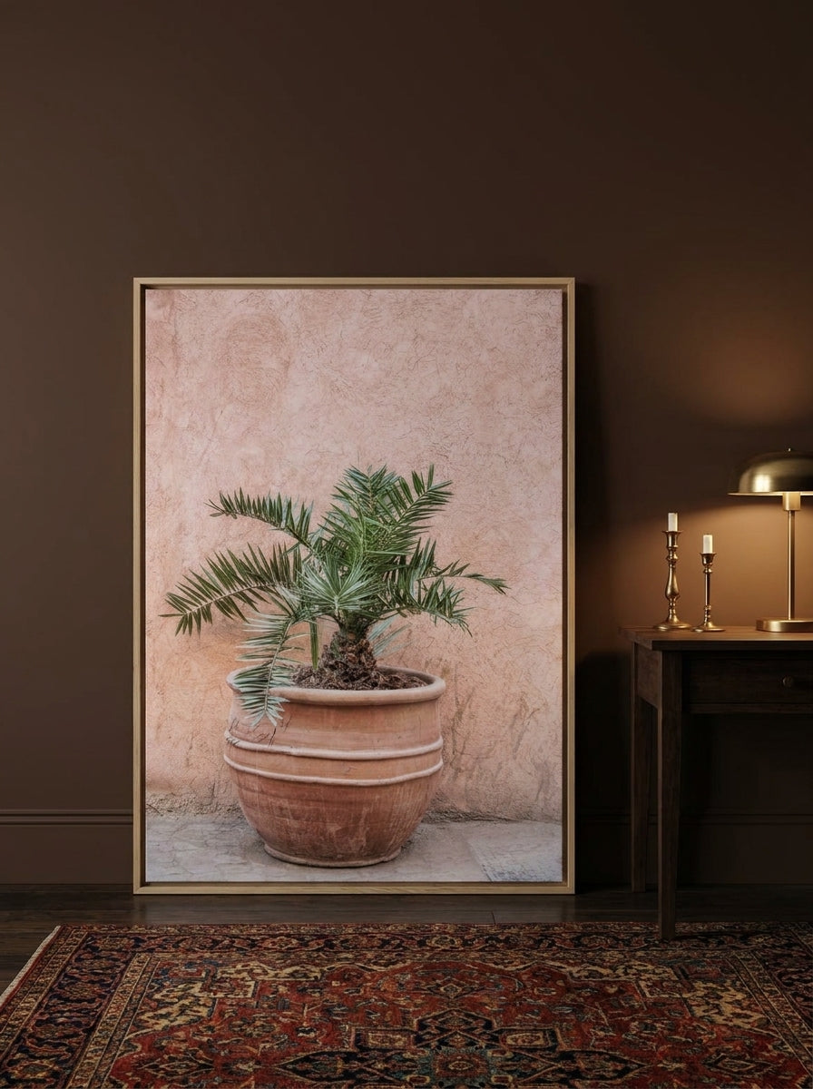Oversized statement canvas wall art with a natural timber surround leaning against the wall in a moody dining room