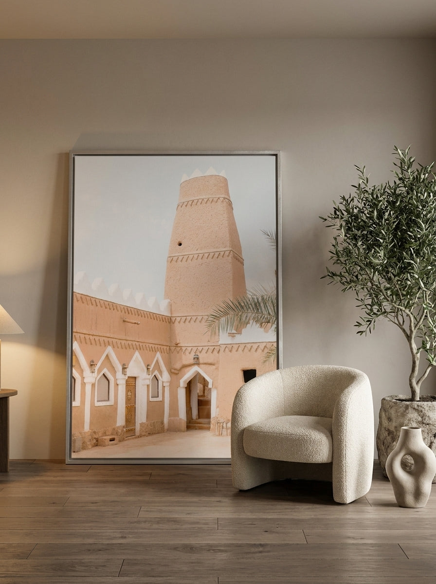 Oversized statement canvas wall art with a silver leaf surround leaning against the wall in a luxe bedroom