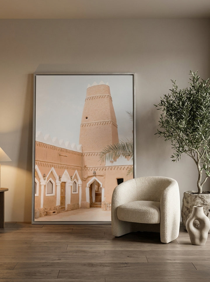 Oversized statement canvas wall art with a silver leaf surround leaning against the wall in a luxe bedroom