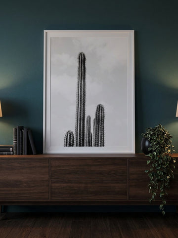 Modern wall art print standing on a sideboard in a moody bedroom