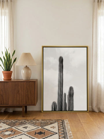 Canvas wall art with a gold leaf surround standing on a sideboard in a mid-century home office