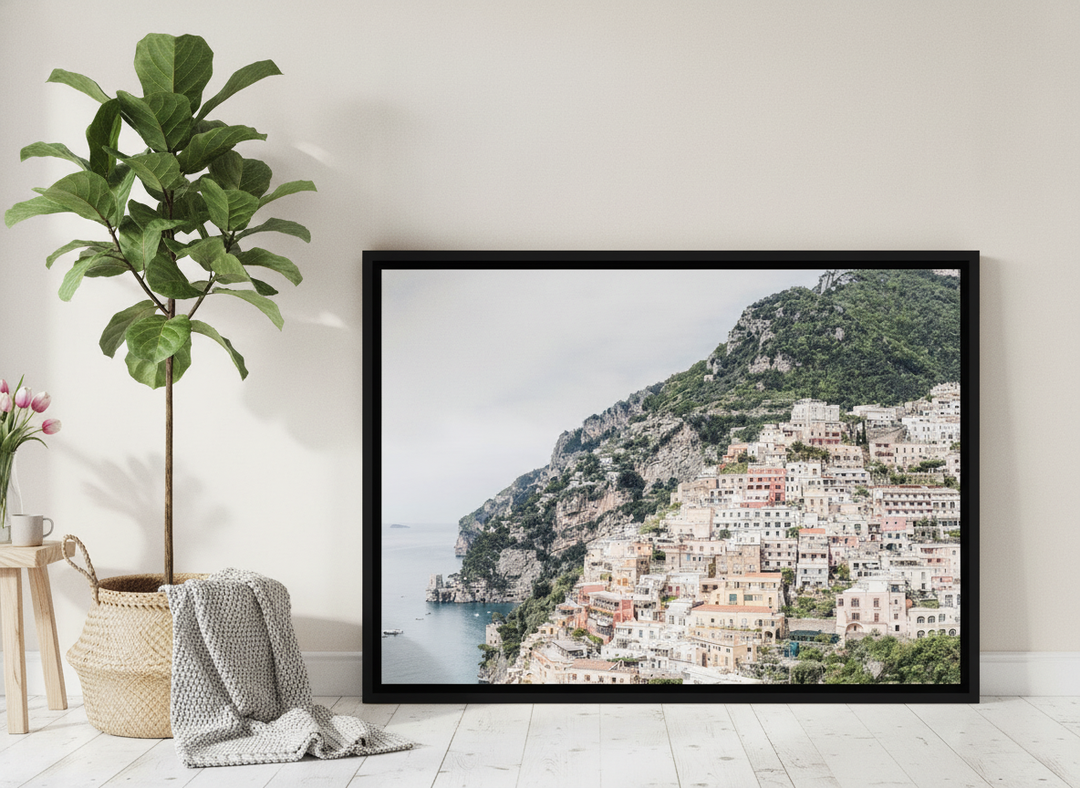 Canvas wall art with a black surround leaning against the wall in a bright Scandinavian living room