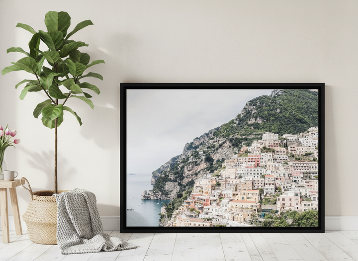 Canvas wall art with a black surround leaning against the wall in a bright Scandinavian living room