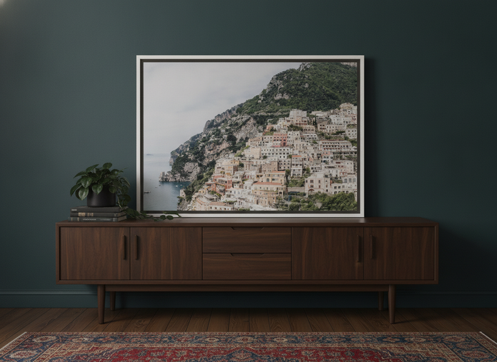 Canvas wall art with a white surround standing on a sideboard in a moody home office