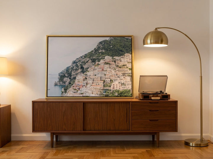 Canvas wall art with a gold leaf surround standing on a sideboard in a mid-century bedroom